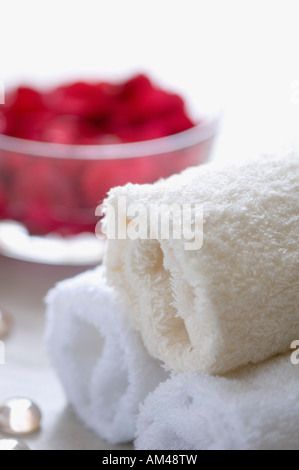 Close-up de pétales de rose dans un bol avec 3 serviettes blanches laminées Banque D'Images