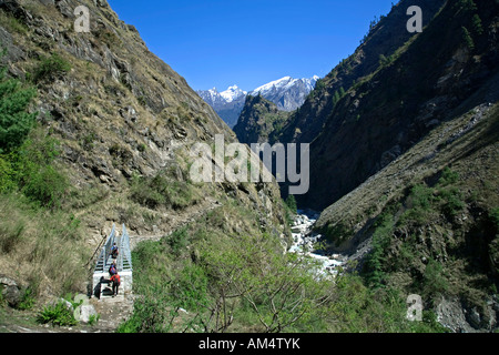 Les randonneurs de traverser un pont sur la rivière Marsyangdi. Circuit de l'Annapurna trek. Près de village de Tal. Le Népal Banque D'Images