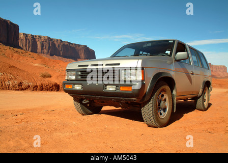 Un SUV à quatre roues motrices sur un chemin de terre par Monument Valley, Arizona. Banque D'Images