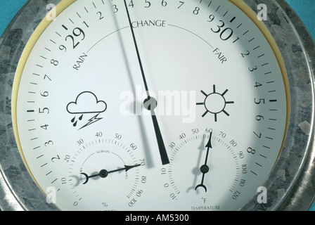 Gros plan d'une jauge Météo montrant plusieurs cadrans et aiguilles et d'une icône de pluie et soleil et nuages thunder Banque D'Images