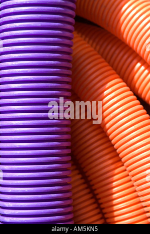 Violet et orange flexible tuyau ondulé conduit de bobines de câble du manteau. Tubulures utilisées comme conduit pour câble haut débit et fibre optique Banque D'Images