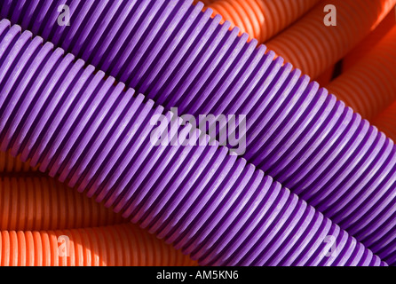 Violet et orange flexible tuyau ondulé conduit de bobines de câble du manteau. Tubulures utilisées comme conduit pour câble haut débit et fibre optique Banque D'Images