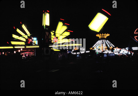 Carnival midway la nuit éclairée par les lumières de la rides Banque D'Images