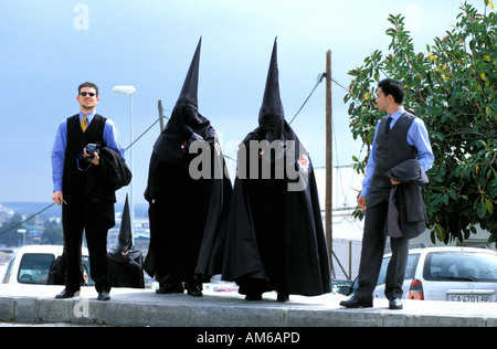 Jerez de la Frontera durant la semaine sainte de l'Est sont pénitents cagoulés marchant dans la rue pour rejoindre leur fraternité Banque D'Images