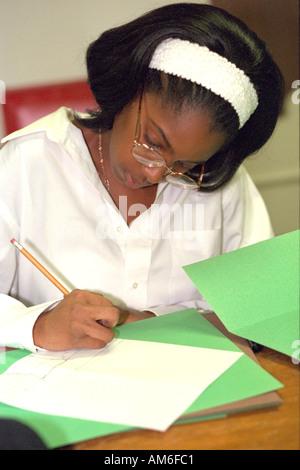 Fille de 14 ans écrit au centre communautaire pour les jeunes. St Paul Minnesota USA Banque D'Images