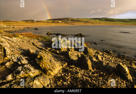 À l'échelle Brighouse Bay sur la côte de Solway Firth à l'obscurité des nuages de pluie et arc-en-ciel près de Kirkcudbright Galloway Scotland UK Banque D'Images