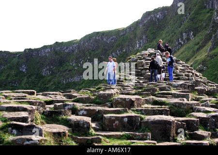 Les touristes prudemment sur les énormes rochers de la Chaussée des Géants, un site protégé du patrimoine mondial, Co Antrim Irlande du Nord Banque D'Images