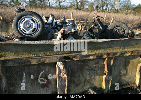 Une voiture accidentée récupéré de la terre et des déchets jetés dans un aller Banque D'Images