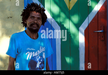 Portrait d'une Afrique du Sud vivant dans le canton de Oudtshoorn en face de l'drapeau sud-africain peint sur une porte Banque D'Images