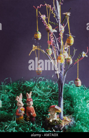 Un joli thème de Pâques toujours droit à l'aide d'accueil des décorations de Noël et bibelots knick. Une famille lapin se tient sous un arbre d'oeufs. Banque D'Images