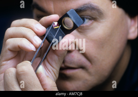 Diamond cutter examine un 2 carats de diamants d'Argyle en pierre rose, Perth, Australie occidentale Banque D'Images