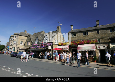 Les touristes se promener le long de la rue principale en anglais populaire destination touristique Kingham, les Cotswolds Gloucestershire Banque D'Images