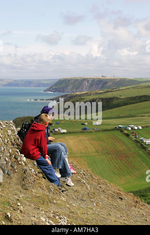 Une jeune famille reste à partir de la marche randonnée sur clifftops avec vue sur la baie de Cardigan Mwnt Irish Sea coast Mid Wales UK GO Banque D'Images