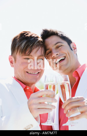 Young gay couple toasting with champagne Banque D'Images