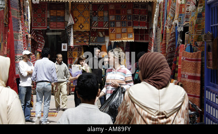 Les touristes dans une ruelle en face d'un magasin de tapis, Essaouira, Maroc Banque D'Images