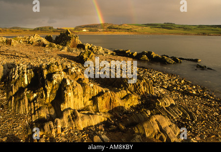 À l'échelle Brighouse Bay sur la côte de Solway Firth à l'obscurité des nuages de pluie et arc-en-ciel près de Kirkcudbright Galloway Scotland UK Banque D'Images