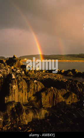 À l'échelle Brighouse Bay sur la côte de Solway Firth à l'obscurité des nuages de pluie et arc-en-ciel près de Kirkcudbright Galloway Scotland UK Banque D'Images