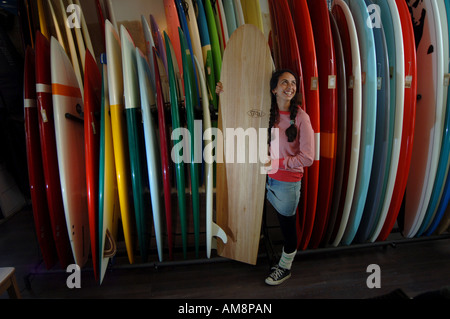 Un female sales assistant est maintenant un surf dans la Loose-fit surf shop à Ilfracombe, Devon, UK. Banque D'Images