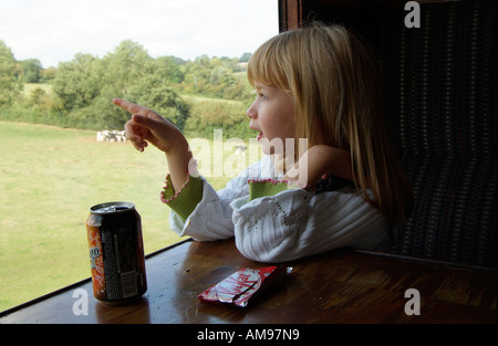 Petite fille dans un train qui admire la vue. Le sud de l'Angleterre, Royaume-Uni Banque D'Images