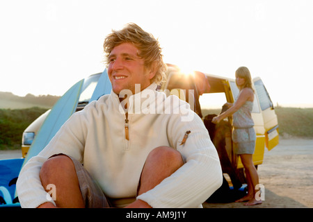 Man sitting on beach at femme van de déchargement à la plage . Banque D'Images