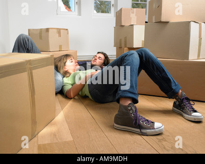 Couple sur marbre avec moving boxes autour d'eux. Banque D'Images