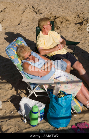 Plus de Swanage Dorset UK senior couple endormi au soleil sur la plage Banque D'Images