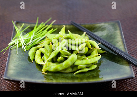 Sur une plaque d'Edamame avec des baguettes Banque D'Images