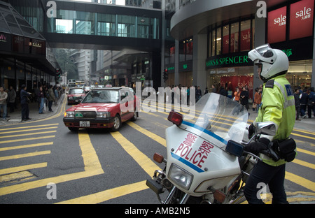 dh des Voeux Rd CENTRE DE HONG KONG policier de moto observer taxi route contrôle de la circulation police moto Banque D'Images