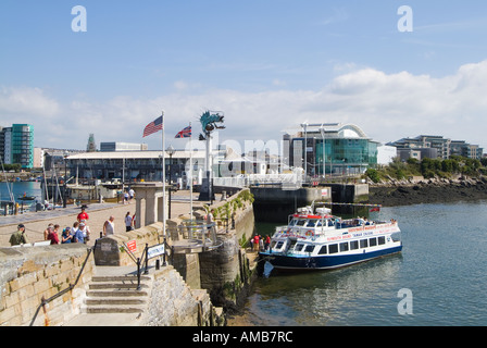 Les visiteurs et un bateau de croisière dans le port au bord des Marches historiques de Mayflower sur le Barbican, Plymouth, Royaume-Uni Banque D'Images