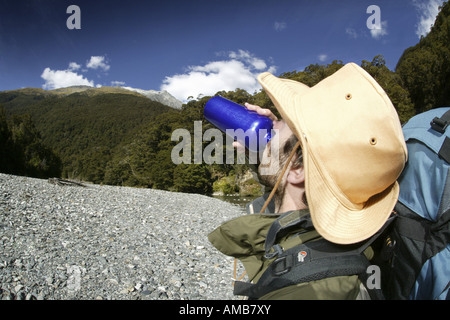 Le randonneur boire d'une bouteille, Nouvelle Zélande Banque D'Images