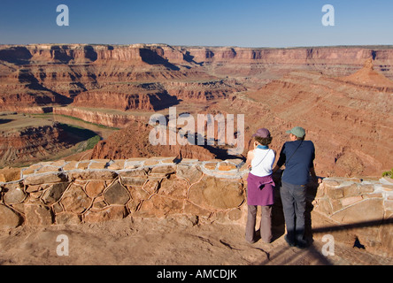 Les visiteurs de Dead Horse Point State Park prendre dans la vue d'un des surplombe près de Moab Utah Banque D'Images