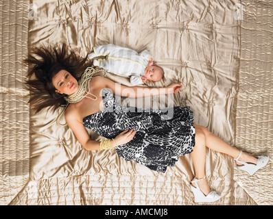 Woman Lying on bed with Baby Banque D'Images