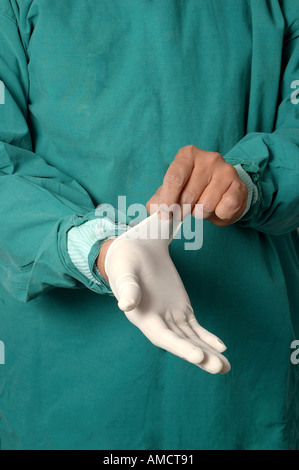 Jeune Indien médecin chirurgien en salopette verte portant des gants chirurgicaux sans latex de caoutchouc blanc seulement sur les mains modèle libération Nombre 637 Banque D'Images