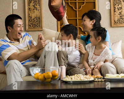 Famille Body Glamour sur canapé rire Banque D'Images