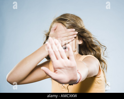 Girl couvrant les yeux et tendant la main Banque D'Images