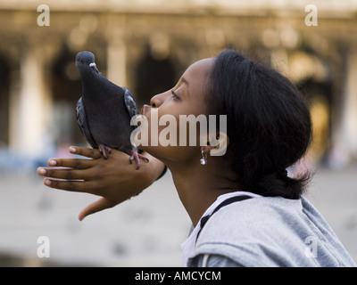 Profil de woman kissing pigeon perché sur la main Banque D'Images