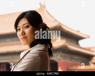 Businesswoman smiling outdoors with pagoda en arrière-plan Banque D'Images
