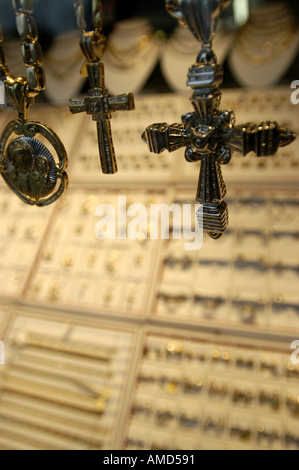 Close up cross colliers suspendues au-dessus de la crème de texture VERTICAL tissu Banque D'Images