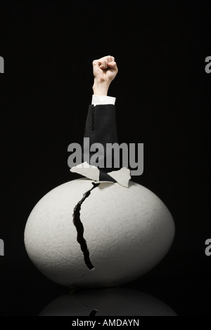 Avec des oeufs fêlés poing serré dans les affaires Banque D'Images
