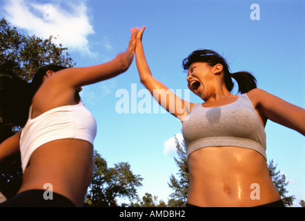 Deux femmes donnant à l'extérieur transpirant High Five Banque D'Images