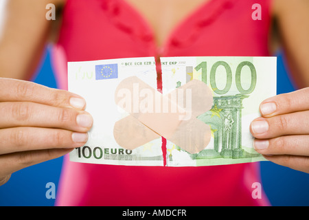 Femme avec une centaine de déchiré dollar euro banknote avec bandes en plastique Banque D'Images