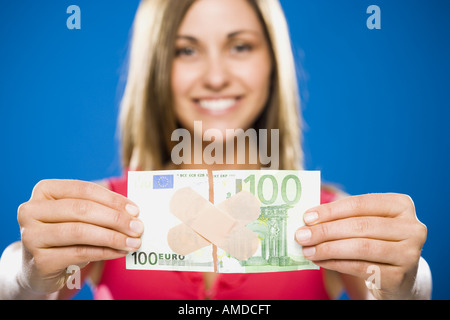 Femme avec une centaine de déchiré dollar euro banknote avec bandes en plastique Banque D'Images