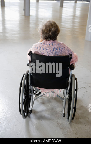 Vue arrière d'une vieille femme assise dans le fauteuil roulant. Banque D'Images