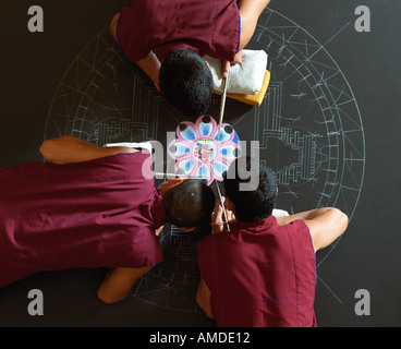 Monks pour sable dans des conceptions complexes pour créer le mandala Banque D'Images