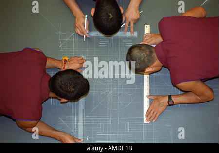 Trois moines dessiner à la craie conçoit comme la première étape de la création de mandala Banque D'Images