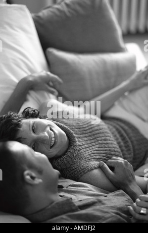 Couple Relaxing on Sofa, Rire Banque D'Images