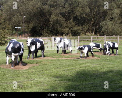 Groupe de vaches fransiennes noires et blanches dans une sculpture en béton dans un parc à Milton Keynes une nouvelle ville de 1967 dans Buckinghamshire Angleterre Royaume-Uni Banque D'Images