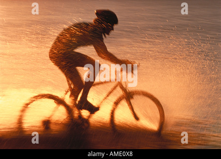 Silhouette of Man Randonnée à vélo à travers l'eau de l'Ontario, Canada Banque D'Images