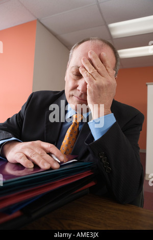 Vue d'un épuisé businessman sitting in office. Banque D'Images