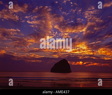 Haystack rock se trouve au large de Cape Kiwanda sur la côte de l'Oregon comme vu au coucher du soleil Banque D'Images